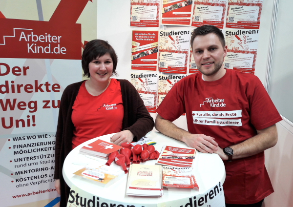 Unsere Bundeslandkoordinatorin Jaana und Mentor Fabian aus Stuttgart lächeln in die Kamera. Sie stehen an ihrem Infostand auf der Messe Horizon. (Foto: ArbeiterKind.de)